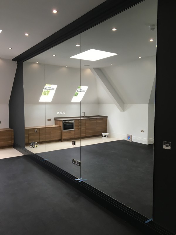 Frameless glass partition in loft conversion by Hayes glaziers
